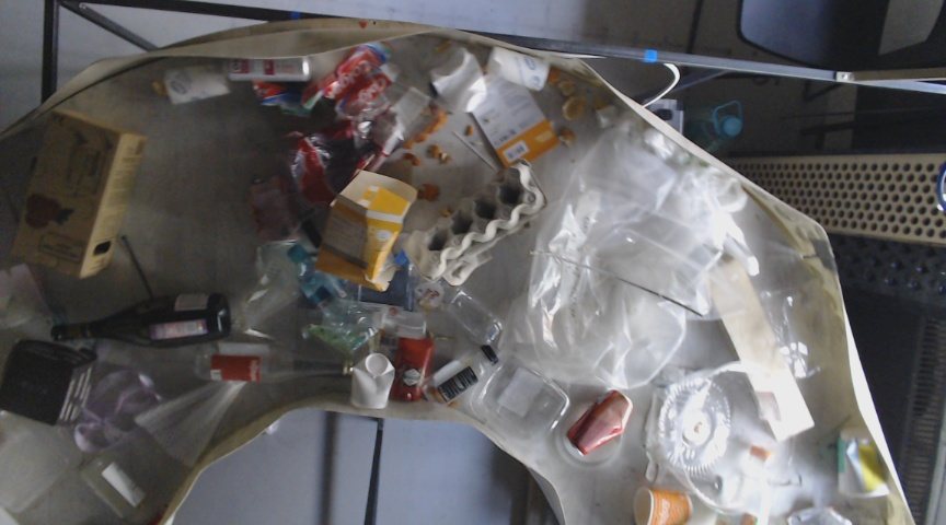 Wider photo of the round sorting table with waste, camera further away.