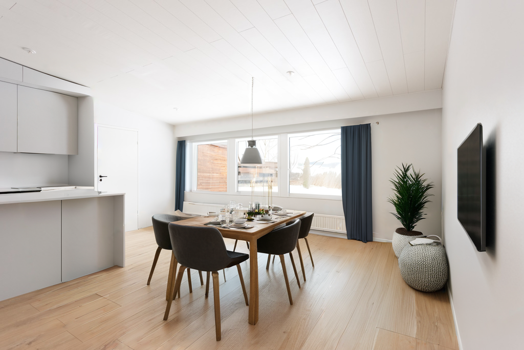 The room next to the kitchen staged with a dining set and plants.